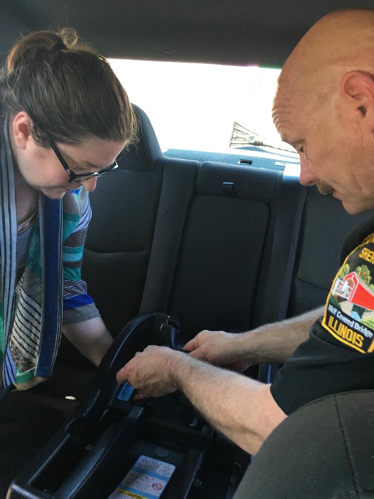 Photo of Deputy Cates assisting with installing a car seat